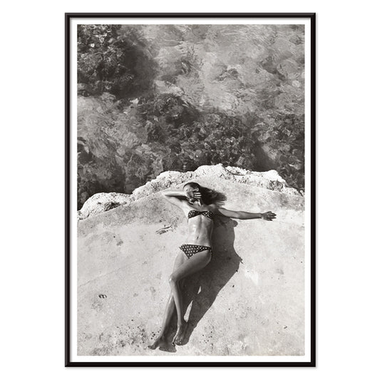 Woman in bikini lying on platform near water in Montego Bay Jamaica artwork by Nickerson Paine poster, with black aluminium frame on white background