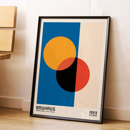 Bauhaus Poster 17 abstract geometric design with intersecting circles in orange red black on blue and beige background by Bauhaus artist framed with text at the bottom, framed and displayed in modern living room decor