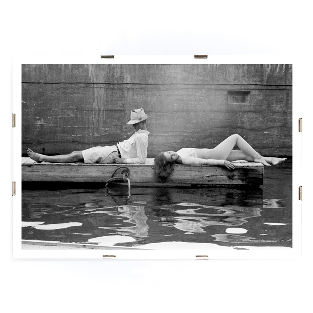 Marquess of Tavistock Henry Robin Ian Russell and Henrietta Tiarks relaxing on a dock in Bermuda by Toni Frissell poster, framed and displayed in modern living room decor
