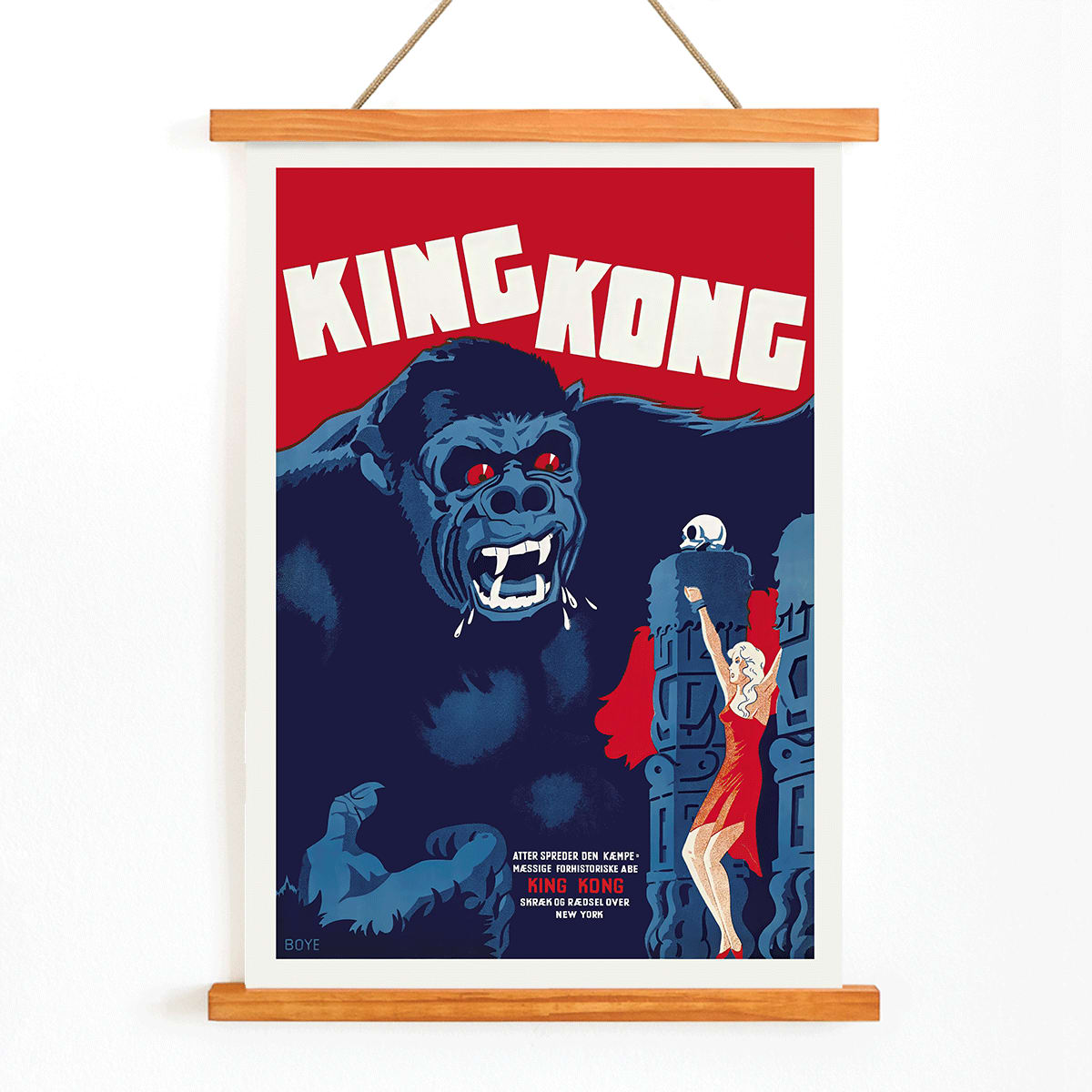 King Kong movie poster by Boye showing giant gorilla with red eyes grabbing a building and a woman in a red dress in an iconic scene, with wooden magnetic frame on white background