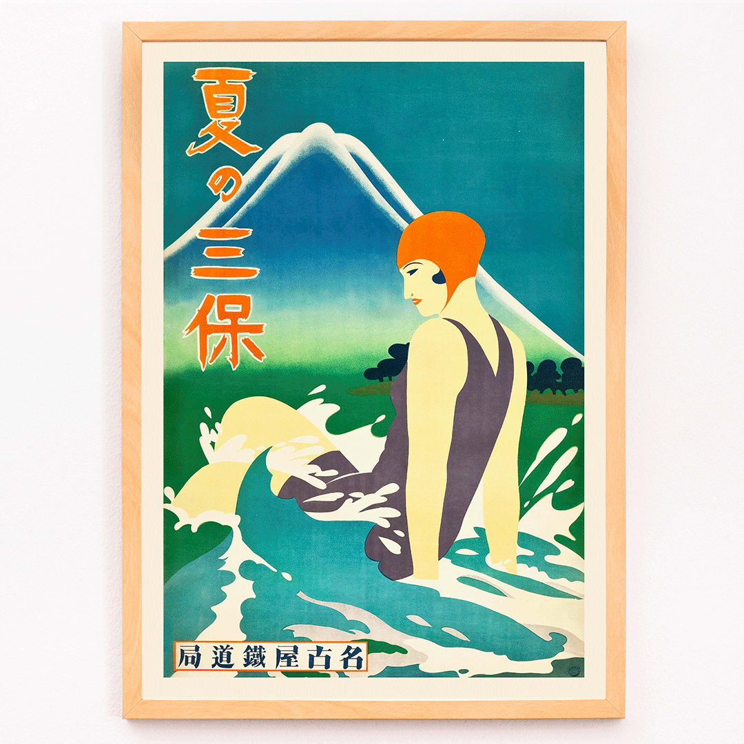 Japanese woman in bathing suit with orange cap sitting in waves at Miho Peninsula with Mount Fuji in background by Nagoya Rail Agency, framed and displayed in modern living room decor