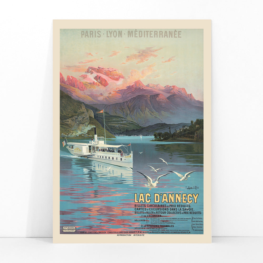 Poster of Le Lac d Annecy by Frederic Hugo d Alesi showing a scenic mountain lake with boat and seagulls at sunset, framed and displayed in modern living room decor