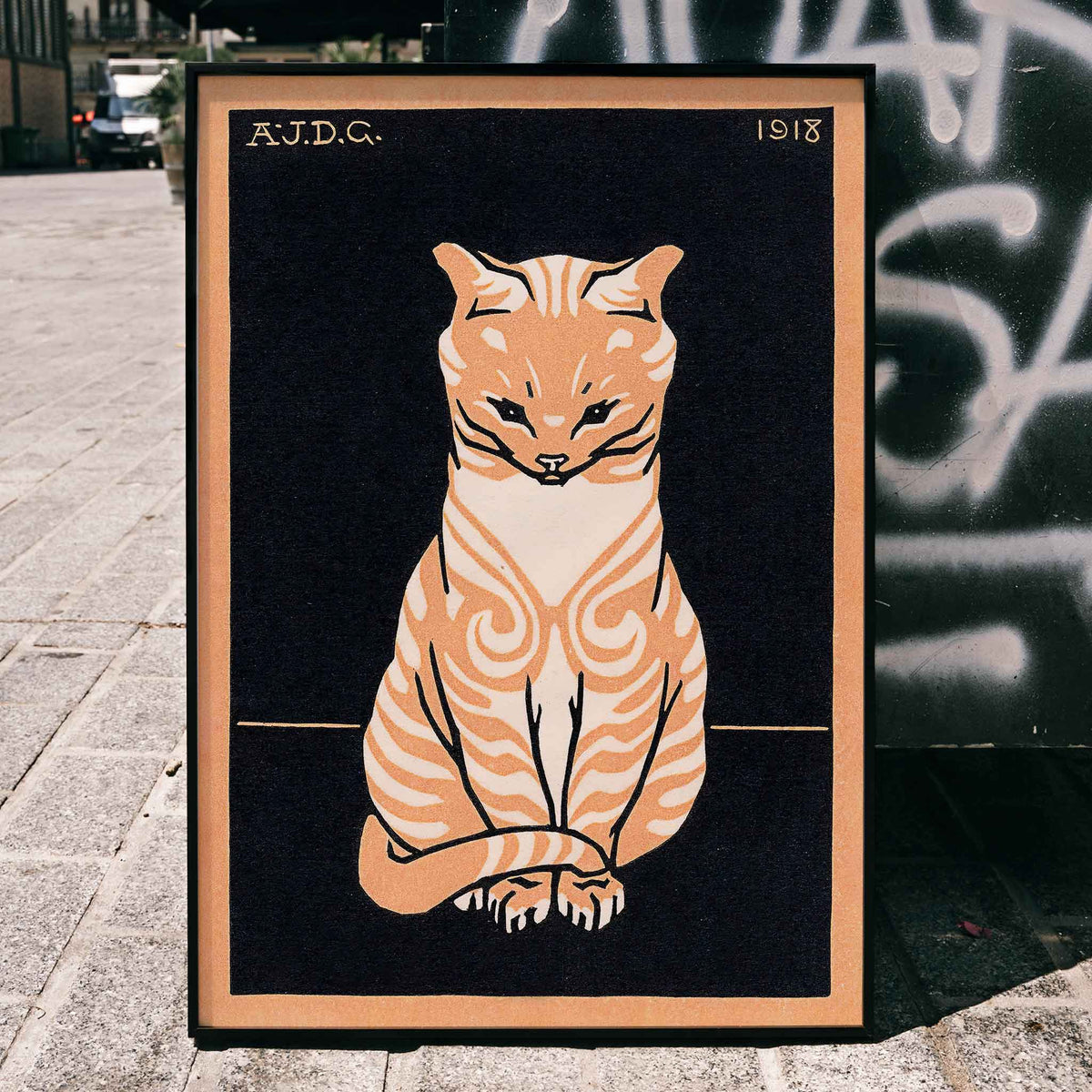Julie de Graag Orange Seated Cat poster with striped tabby, pale chest and curled tail on black background, framed and displayed in home decor