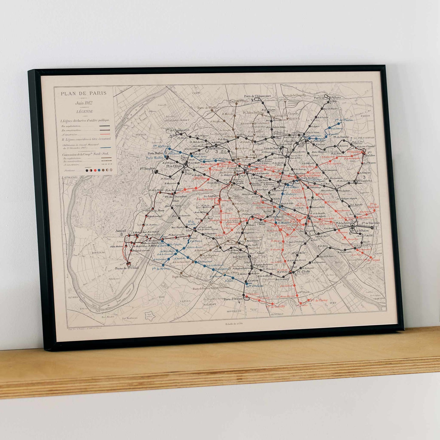 Louis Wuhrer Paris metro map poster vintage city plan with black and red rail lines, framed and displayed in modern living room decor