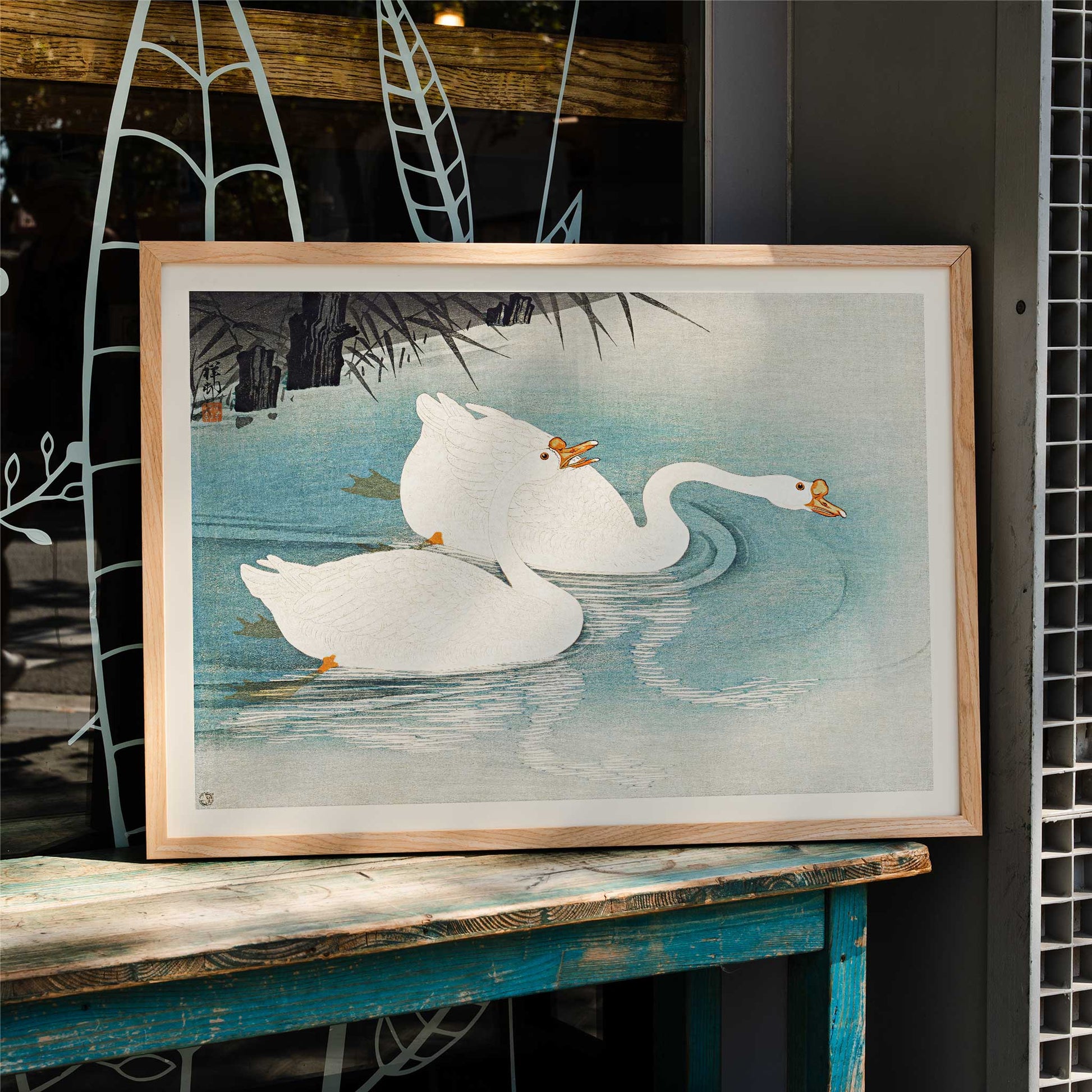 White geese swimming among blue water and reeds Geese amid Reeds by Ohara Koson poster, framed and displayed in home decor