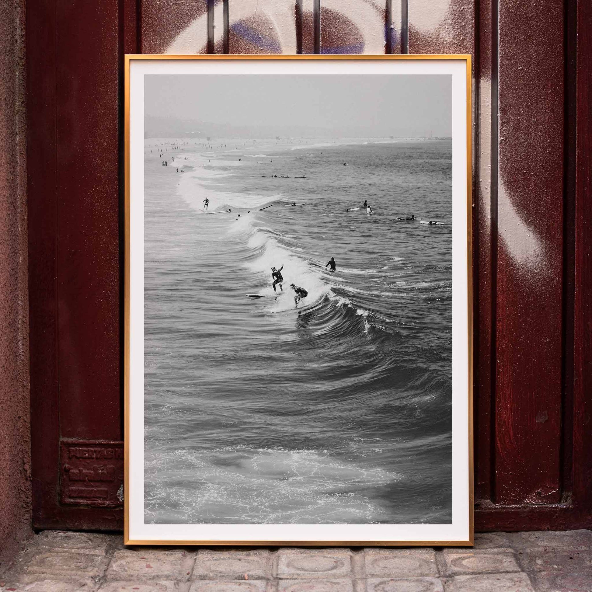 Black and white surfers riding waves at Venice Beach coastal wall art poster ideal for home decor, framed and displayed in home decor