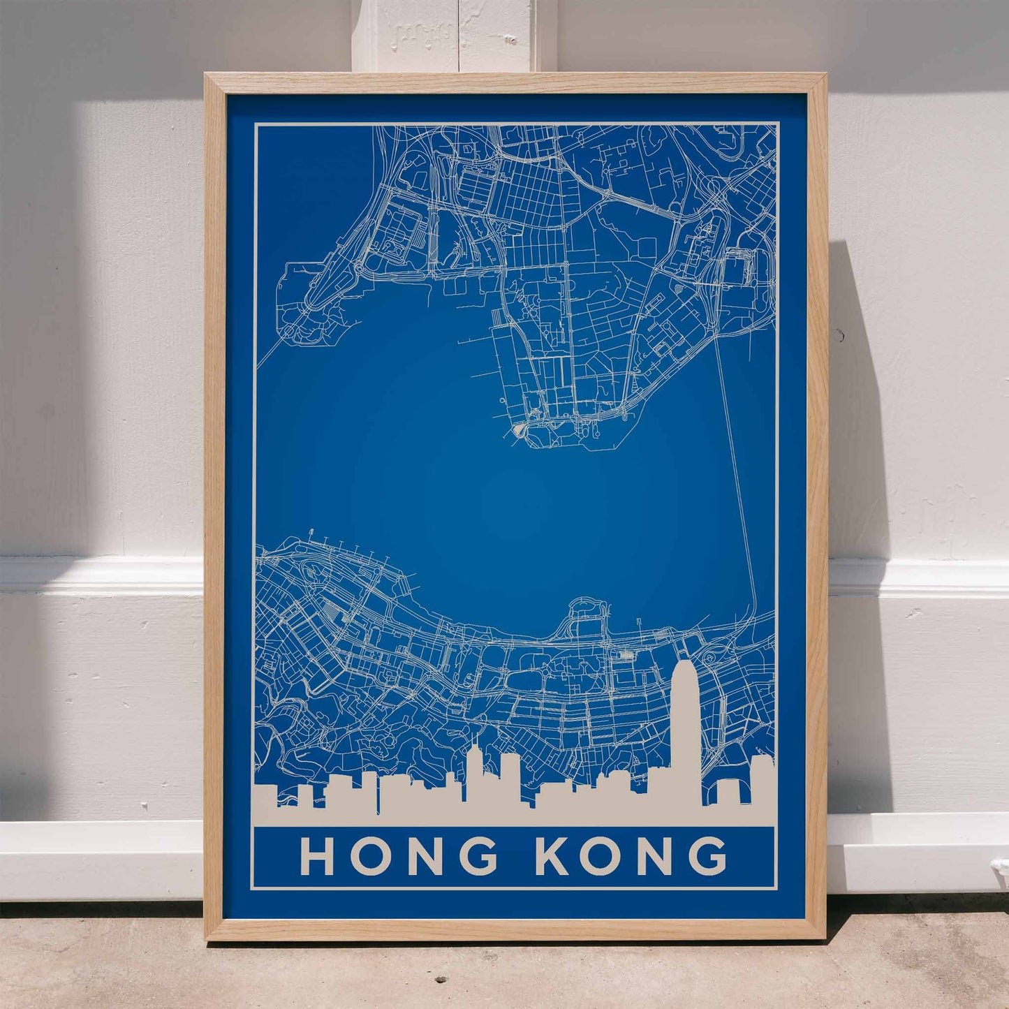 Hong Kong Minimalist Map by Artist Name blue urban blueprint wall art poster featuring city skyline and street layout, framed and displayed in home decor
