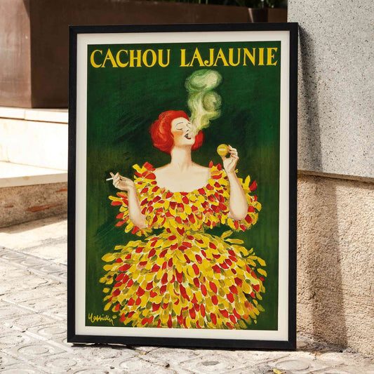 Colorful poster Cachou Lajaunie by Leonetto Cappiello featuring a woman in a vibrant dress with smoke forming a face and holding a cigarette, framed and displayed in home decor
