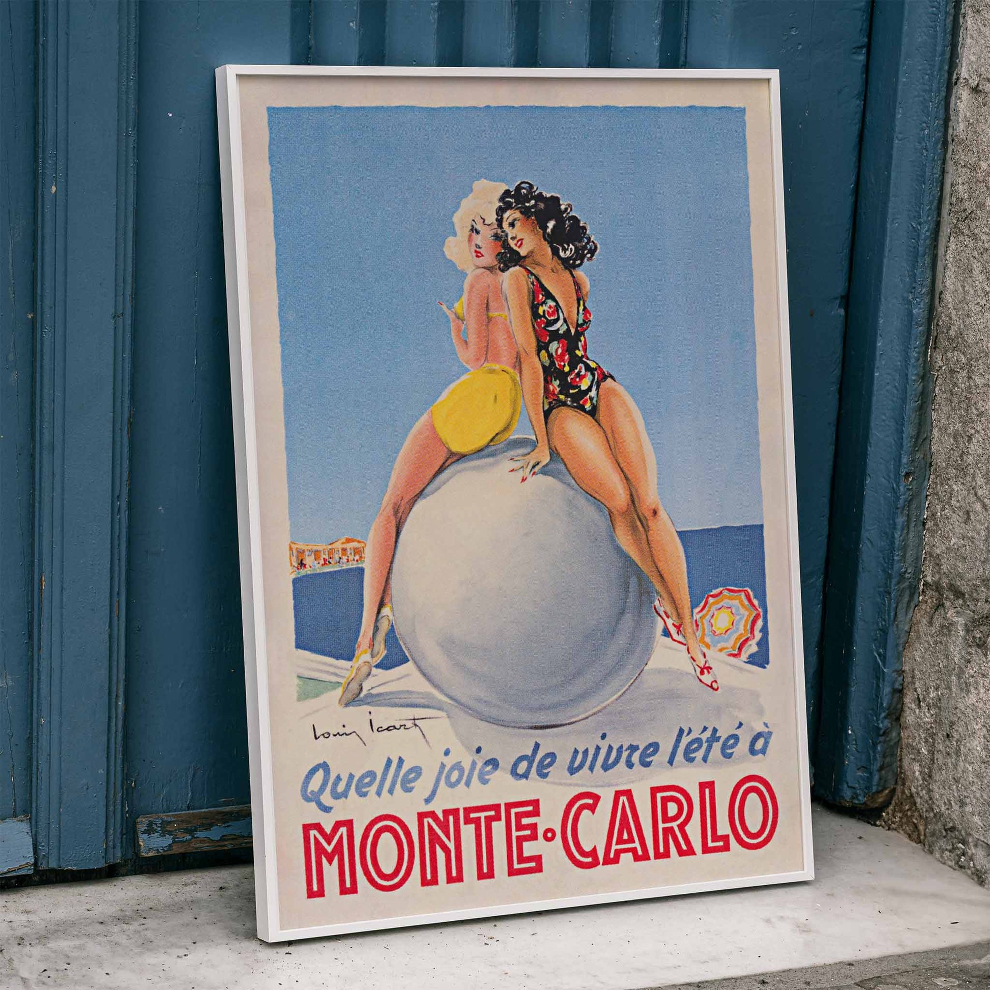Monte Carlo artwork by Louis Icart showing two women in swimsuits sitting on a large ball at the beach poster, framed and displayed in home decor