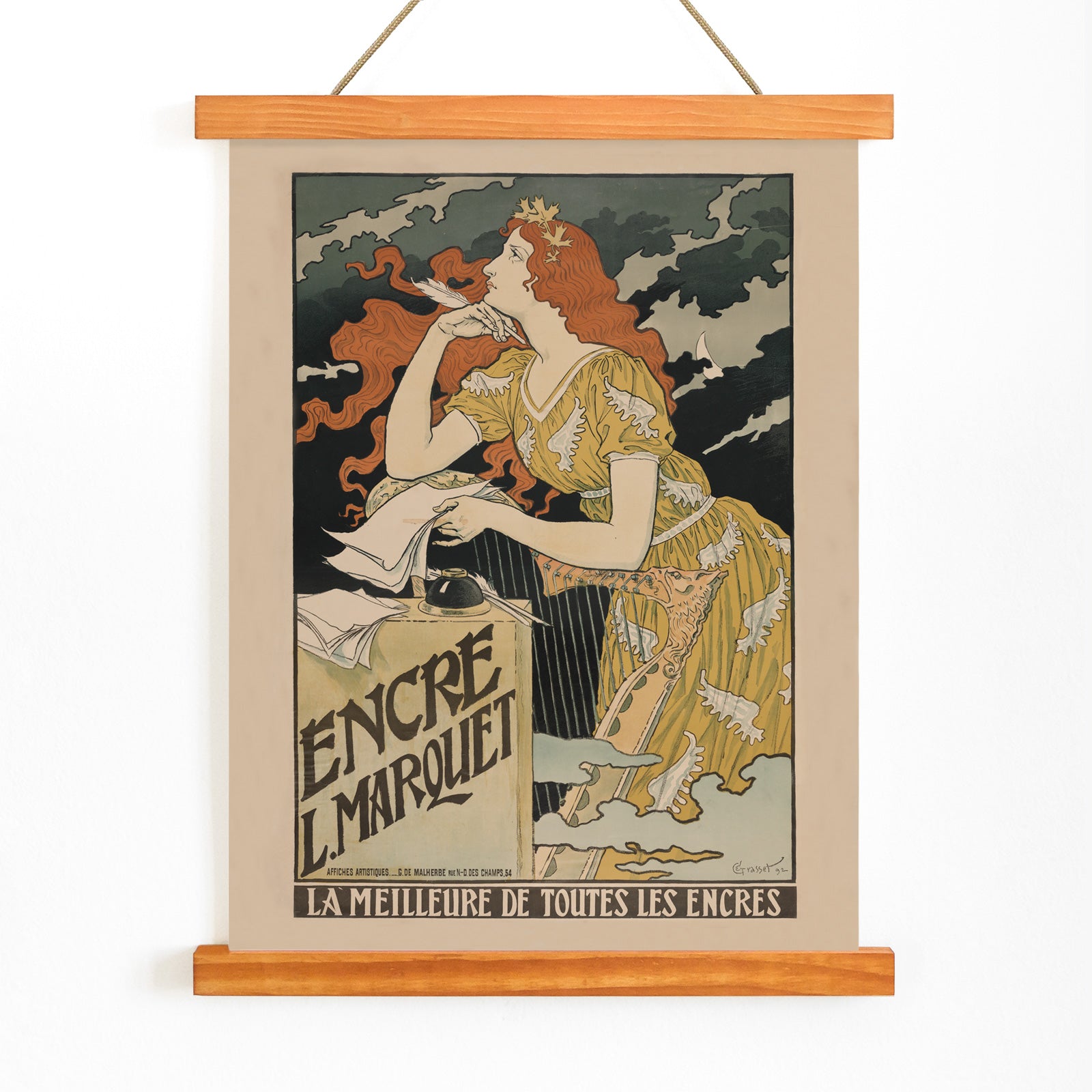 Art Nouveau poster of a woman in a yellow dress with flowing red hair writing at a desk for Encre Marquet by Eugene Grasset, with wooden magnetic frame on white background
