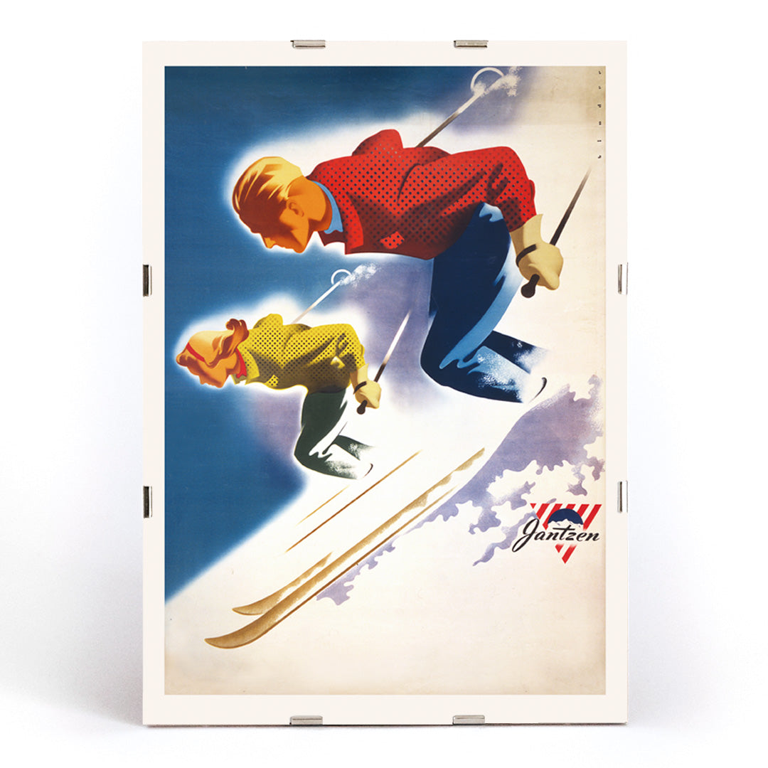 Vintage skiing poster of man and woman skiing downhill in bold colors by Joseph Binder for Jantzen, framed and displayed in modern living room decor